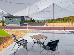 タープの下にテーブルイスを配置している様子