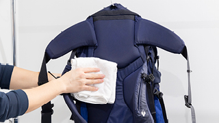 バックパックを上下逆さまにし、タオルを当て、水気を切っている