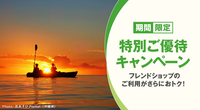 夕日の沈む海でカヤックに乗る二人