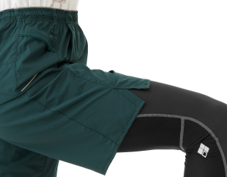 裾にスリットを備えたショーツを履いて足上げしている機能写真