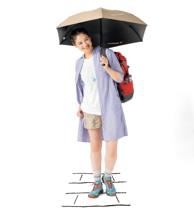 白いTシャツとベージュのショートパンツの上にラベンダー色のシャツワンピース羽織った女性モデル。茶色い日傘をさしている